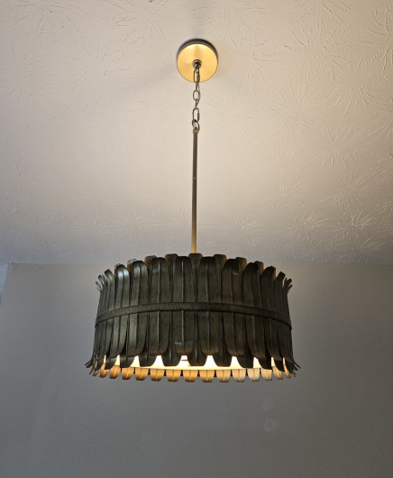 A light fixture hung from a sloped ceiling by a chain in a kitchen