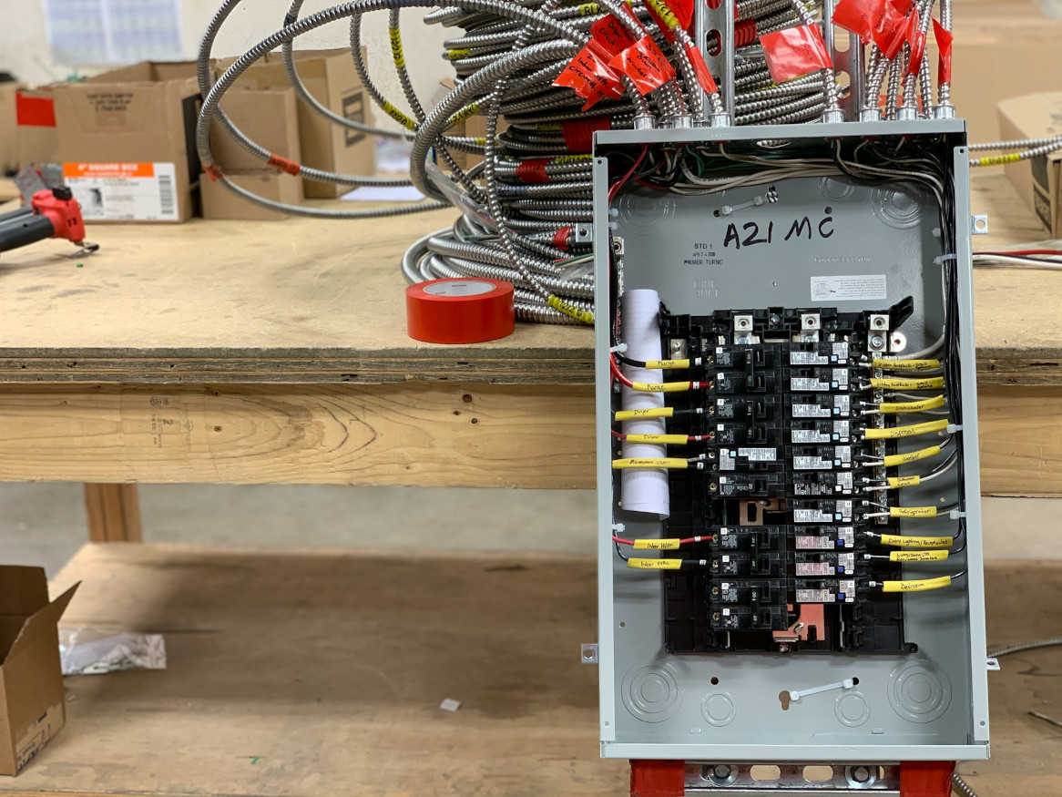 An open electrical panel leaning ona wooden table